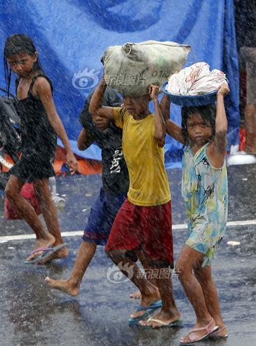 People walk in rain after Typhoon Haiyan hits Tacloban City of Leyte Province, the Philippines, on Nov. 10, 2013. 