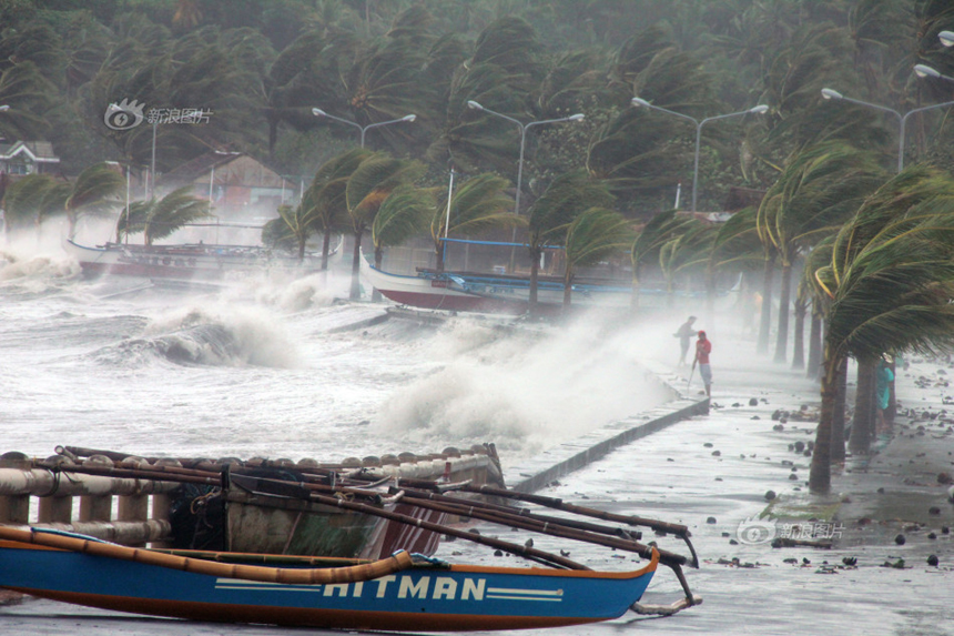 People stand on the seaside embankment in Legaspi City of Albay Province, the Philippines, on Nov. 8, 2013. 