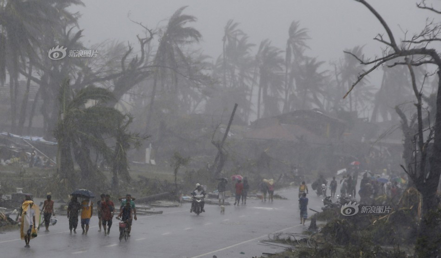 People walk in rain after Typhoon Haiyan hits Tacloban City of Leyte Province, the Philippines, on Nov. 9, 2013. 