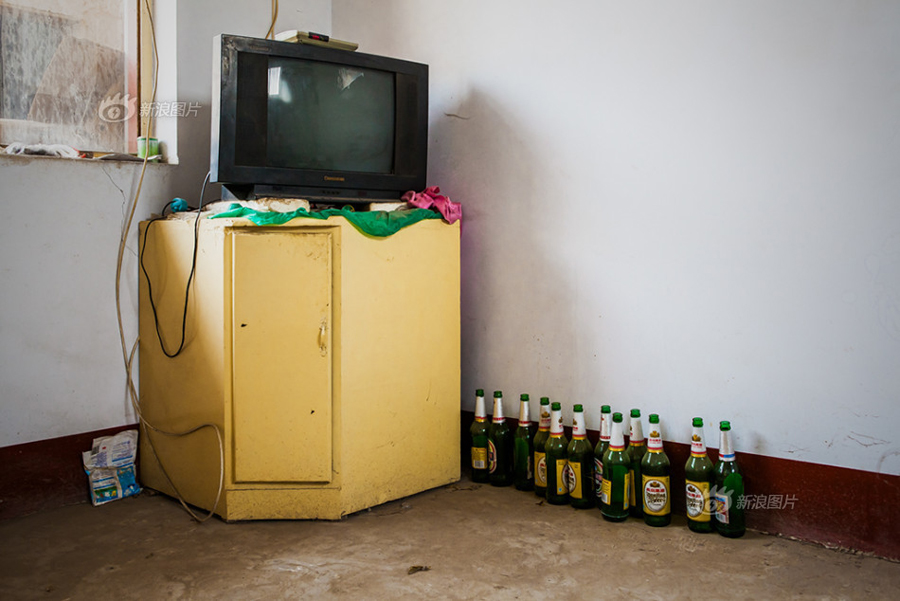 Liu's hobbies are watching TV and drinking beers; The TV cabinet proves he does as it is aligned with empty bottles. He particularly likes watching news and legal programs. [Sina photo]