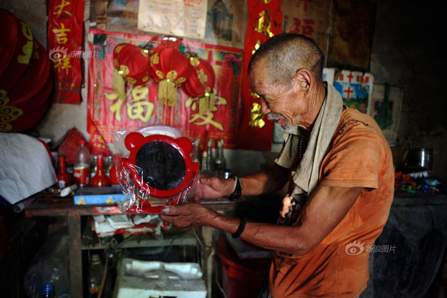 Heiwa's father looks very happy holding a red-framed mirror in hands. He likes red things very much, such as lanterns, wine bottles and coke cans. As long as it's red, he will pick it up and put it on the table as decoration. [Sina photo]