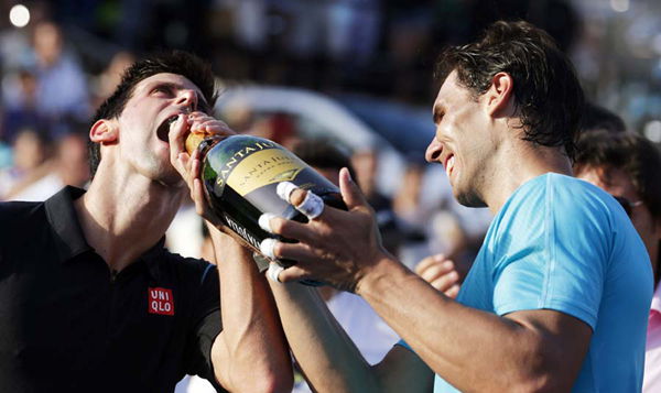  Rafael Nadal (R) of Spain gives champagne to Novak Djokovic of Serbia after defeating him in their exhibition tennis match in Buenos Aires, Nov 24, 2013. 