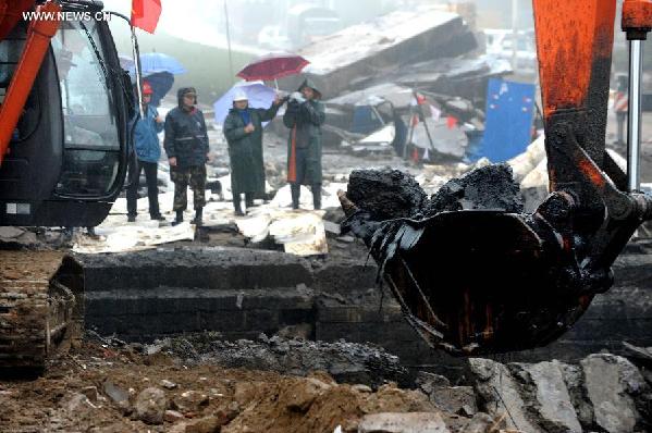 An excavator is used at the site of a pipeline explosion in Qingdao Development Zone, in Qingdao, east China's Shandong Province, Nov. 24, 2013. A leaking pipeline caught fire and exploded on Friday morning in Huangdao District of Qingdao.  (Xinhua/Li Ziheng)