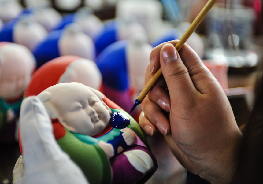 Li Miaojun, a clay-figurine master paints at the Huishan Clay-figurine Workshop in Wuxi City, Jiangsu Province, on Nov. 23, 2013. Clay figurines in this area have a long history. The region is famous for its fine craftsmanship. In 2006 it was included in the national intangible cultural heritage list, although it has been difficult to find talent in recent years. [Translated by Li Jingrong. Photo/Xinhua]