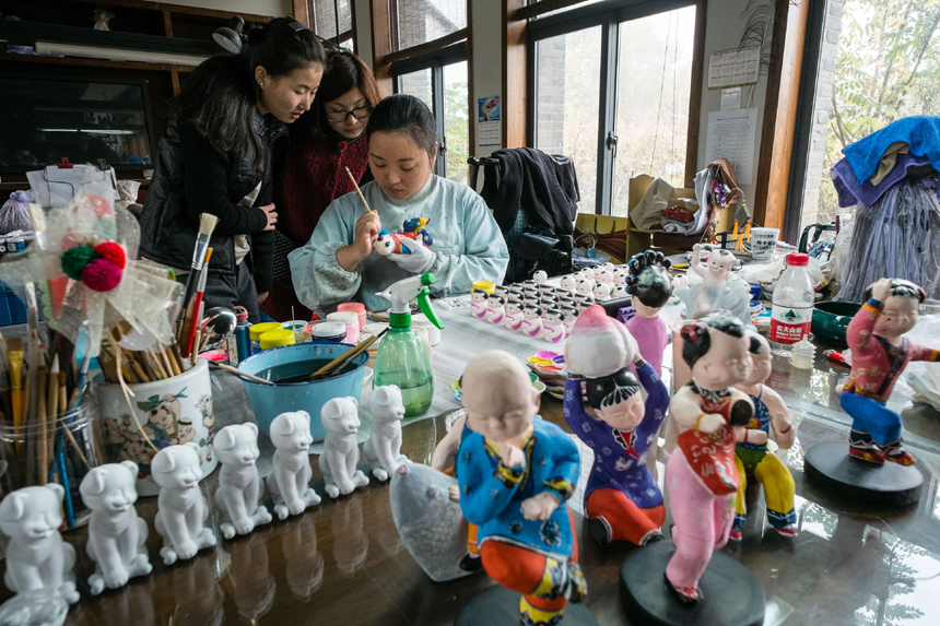 Students study clay-figurine making from Master Li Qin at the Huishan Cay-figurine Workshop in Wuxi of Jiangsu Province, on Nov. 3, 2013. Clay figurines in this area have a long history. The region is famous for its fine craftsmanship. In 2006 it was included in the national intangible cultural heritage list, although it has been difficult to find talent in recent years. [Translated by Li Jingrong. Photo/Xinhua]