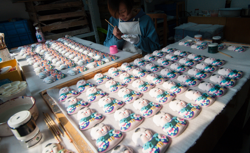 Master Zhao Hong paints at the Huishan Cay-figurine Workshop in Wuxi City of Jiangsu Province, on Nov. 21, 2013. Clay figurines in this area have a long history. The region is famous for its fine craftsmanship. In 2006 it was included in the national intangible cultural heritage list, although it has been difficult to find talent in recent years. [Translated by Li Jingrong. Photo/Xinhua]