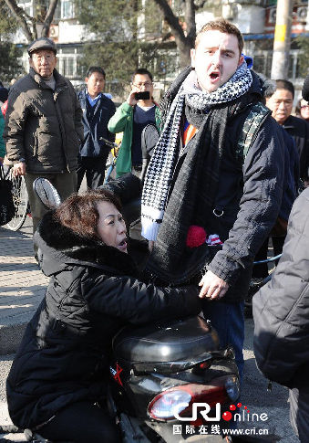 The middle-aged woman was allegedly hit by a motorcycle carrying two people at around 10:33 a.m. Monday, and she then fell to the ground while walking at a pedestrian crossing in Chaoyang District, said Beijing police.