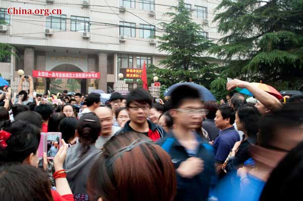 Students file out of the school gate after completing this year's national college entrance exam on Saturday afternoon, June 8, 2013. [Photo / Chen Boyuan]