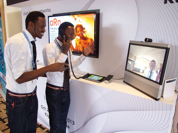 Two Africans try a visual phone at a recent exhibition in Rwanda. [Photo / China Daily]    