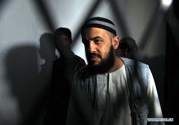  An al-Qaida suspect stands behind bars during a hearing at the state security court in Sanaa, Yemen, on Sept. 12, 2013. A Yemeni court on Thursday acquitted five Saudi nationals of links with al-Qaida, but jailed two of them for illegally entering the country, lawyers said. [Xinhua/Mohammed Mohammed]