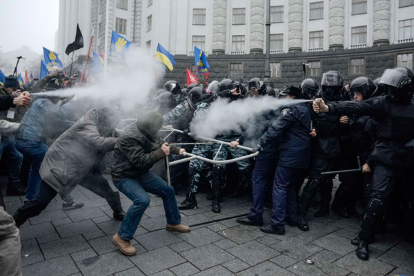Protesters clash with riot police during a rally to support EU integration in central Kiev November 24, 2013. Tens of thousands of supporters of Ukraine's European integration flooded central Kiev on Sunday to protest against the government's decision to drop plans to sign a landmark deal with the European Union in Vilnius on November 29 and to revive talks on ties with Russia. [Photo/China Daily]