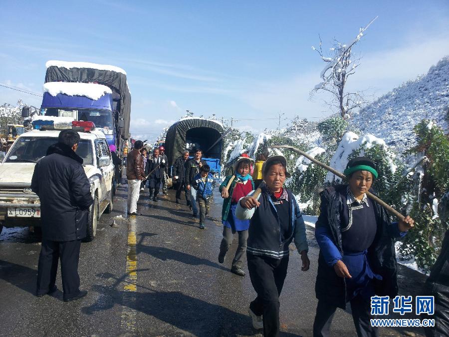 Local people rescue more than 1,400 trapped passengers on a highway stretch in Heqing County, in southwest China's Yunnan Province on Dec. 16, 2013. Snowy weather has battered the province, temporarily shutting down highways and airports, leaving passengers stranded. [Xinhua]