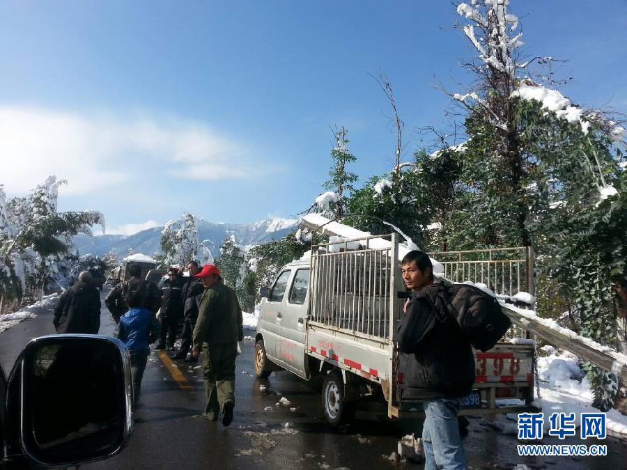 Local people rescue more than 1,400 trapped passengers on a highway stretch in Heqing County, in southwest China's Yunnan Province on Dec. 16, 2013. Snowy weather has battered the province, temporarily shutting down highways and airports, leaving passengers stranded. [Xinhua]