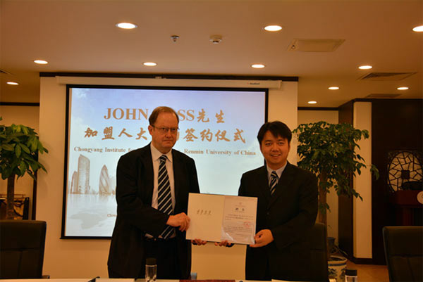 Former Deputy Mayor of London, John Ross, (L) receives a letter of appointment from Wang Wen (R), executive dean of the Chongyang Institute for Financial Studies, on June 1. Ross became the first full time high level foreign member of a Chinese think tank.