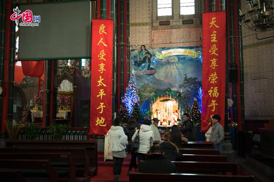 A Christian volunteer (L4) recounts the story of nativity to new comers in the Church of the Saviour (colloquially referred to as Xishiku Church, or Beitang -- the North Cathedral) in Beijing on the afternoon of Dec. 25, 2013, the Christmas Day. [Photo by Chen Boyuan / China.org.cn]