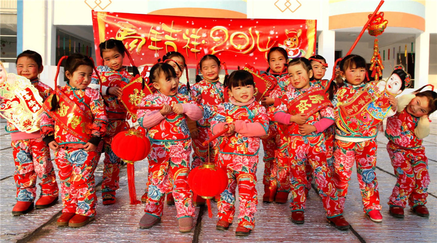 Children from a kindergarten in Shuikou village, Yichun city of East China's Jiangxi province celebrate the New Year as they wear folk costumes and hold red lanterns and Chinese knots. [Photo/Xinhua]