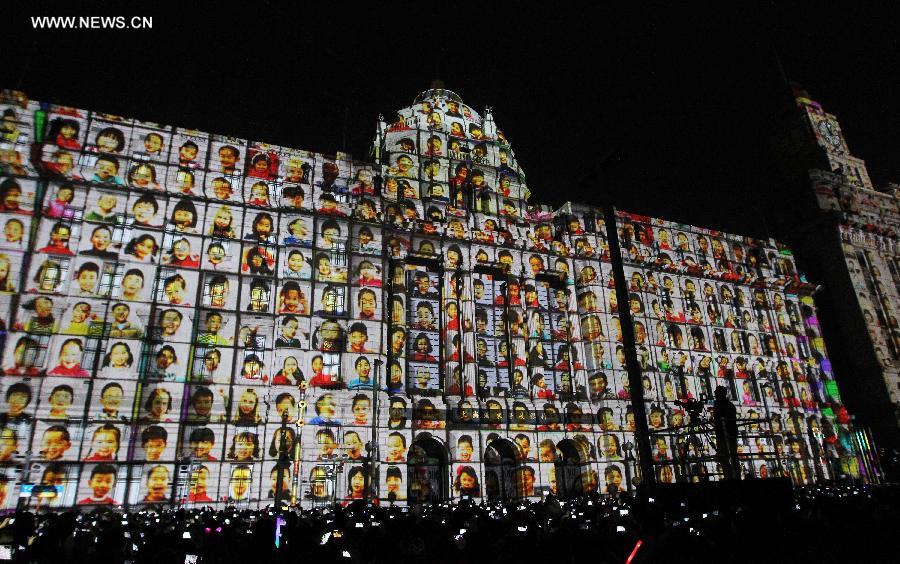 Children's portraits are projected on a building during a count-down event for the new year at the Bund, east China's Shanghai, Dec. 31, 2013. (Xinhua/Ding Ding)
