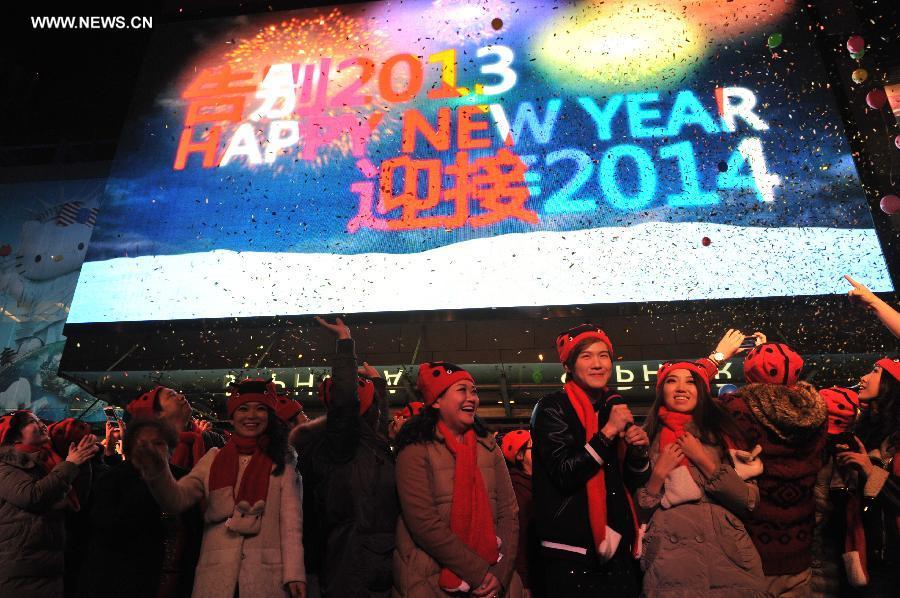 People gather in front of a large screen at a shopping mall to welcome the new year in Tianjin, north China, on Jan. 1, 2014. (Xinhua)