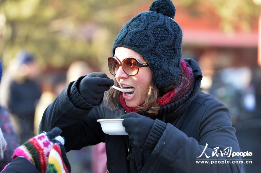  visitor to the Yonghe Lama Temple in Beijing gets her free bowl of Laba porridge offered by the temple on January 8, 2014, which is the Laba Festival according to the Chinese lunar calendar. Eating Laba porridge is a tradition for those who wish to enjoy a good year via this special food made of eight ingredients, also known as the 'eight treasures.'