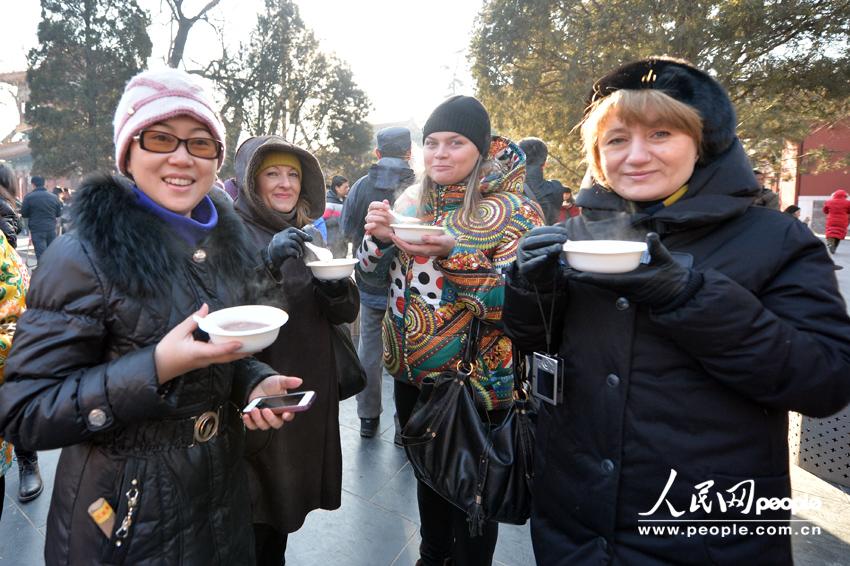 Visitors to the Yonghe Lama Temple in Beijing get their free bowl of Laba Porridge offered by the temple on January 8, 2014, which is the Laba Festival according to the Chinese lunar calendar. Eating Laba porridge is a tradition for Chinese who wish to enjoy a good year by eating this special food made of eight ingredients, known as 'eight treasures.' 