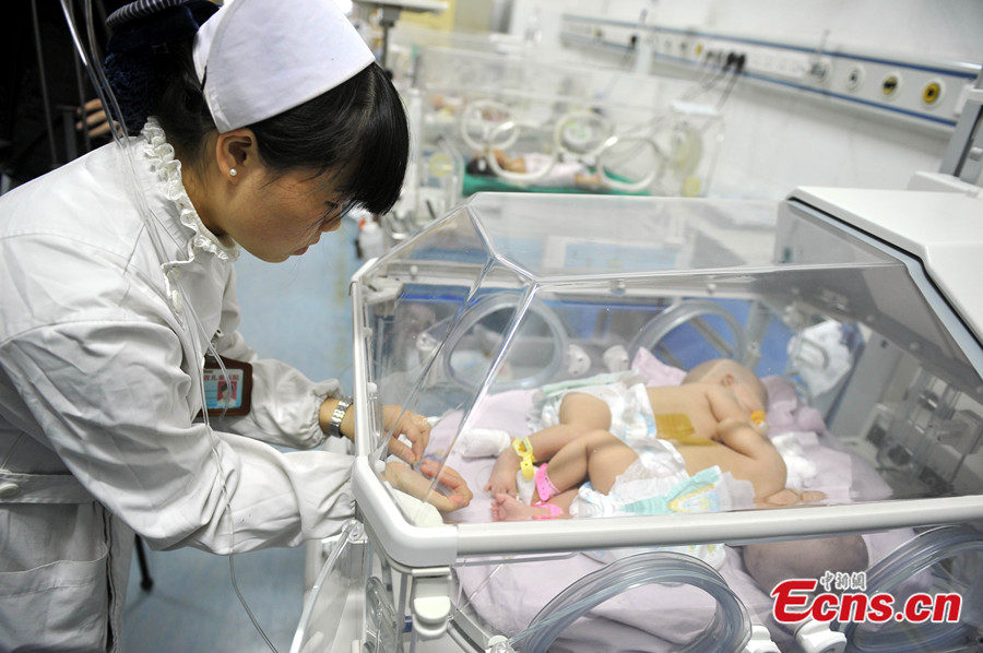 A pair of Chinese conjoined twin sisters, who shared the same liver, are developing normally according to their first hospital checkup since they were separated in August 2013, a hospital source said Tuesday. [CNS photo]