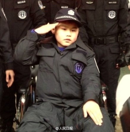 Zou Junyi, diagnosed with muscular dystrophy in Xinyu City, east China's Jiangxi Province, received the award of 'courageous policeman' from Mayor Cong Wenjing after the young boy, wearing a tailored police uniform, helped subdue two 'kidnappers' and save three 'hostages' played by citizen volunteers. [photo / weibo]
