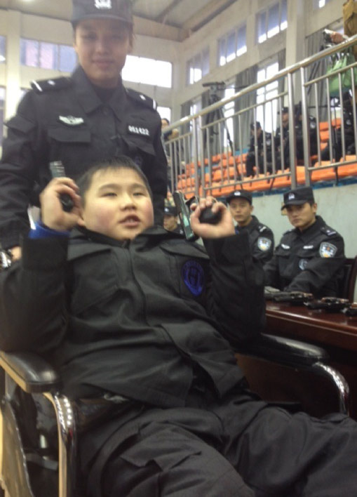 Zou Junyi, diagnosed with muscular dystrophy in Xinyu City, east China's Jiangxi Province, received the award of 'courageous policeman' from Mayor Cong Wenjing after the young boy, wearing a tailored police uniform, helped subdue two 'kidnappers' and save three 'hostages' played by citizen volunteers. [photo / weibo]