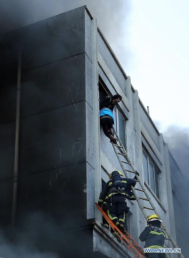 Rescuers try to save people trapped in a factory fire in Wenling, east China's Zhejiang Province, Jan. 14, 2014. A fire broke out at 2:52 p.m. in a shoe factory in Wenling City on Tuesday, leaving at least 16 people dead, the local government said. Firefighters are still searching for survivors. An initial investigation into the cause of the fire is under way. (Xinhua photo)