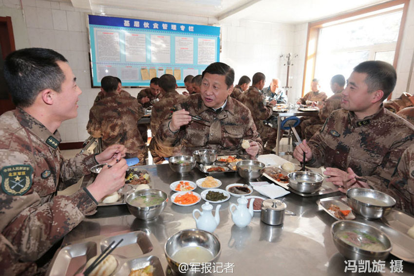 Chinese President Xi Jinping dines together with soldiers in the dining hall of the garrison troops in the Inner Mongolia Autonomous Region Sunday at noon, January 26, 2014. Xi also reminded the army officers to make arrangements for soldiers to have a good time during the Spring Festival. [Photo: PLA Daily] 