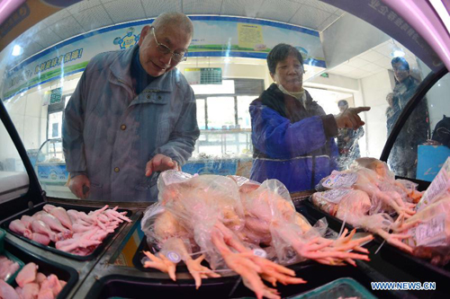 People shop chilled poultry at a market in Shanghai, east China, Jan. 28, 2014. [Xinhua]
