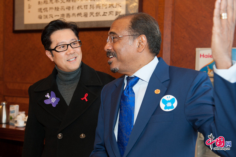 Famous Chinese singer Cai Guoqing (L) talks with Michel Sidibé, UNAIDS Executive Director. The UNAIDS, China Red Ribbon Foundation and Hanergy jointly launch the &apos;Zero Discrimination Day&apos; advocacy event in Beijing on Thursday, Feb. 27, 2014. [Photo by Chen Boyuan / China.org.cn]