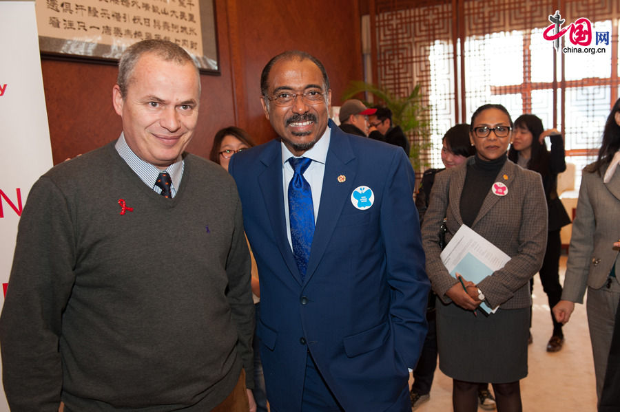 Michel Sidibé, UNAIDS Executive Director (R) and Etienne Poirot, UNICEF HIV/AIDS director in China pose for photos. The UNAIDS, China Red Ribbon Foundation and Hanergy jointly launch the &apos;Zero Discrimination Day&apos; advocacy event in Beijing on Thursday, Feb. 27, 2014. [Photo by Chen Boyuan / China.org.cn]