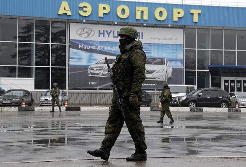 Unidentified armed men patrol outside of Simferopol airport, on February 28, 2014. Ukraine accused today Russia of staging an 'armed invasion' of Crimea and appealed to the West to guarantee its territorial integrity after pro-Moscow gunmen took control of the peninsula's main airport. [Xinhua photo]