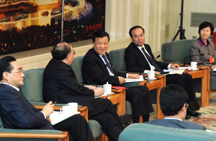 Liu Yunshan (3rd L), a member of the Standing Committee of the Political Bureau of the Communist Party of China (CPC) Central Committee and secretary of the Secretariat of the CPC Central Committee, joins a discussion with deputies to the 12th National People&apos;s Congress (NPC) from southwest China&apos;s Chongqing Municipality during the second session of the 12th NPC, in Beijing, capital of China, March 9, 2014. 