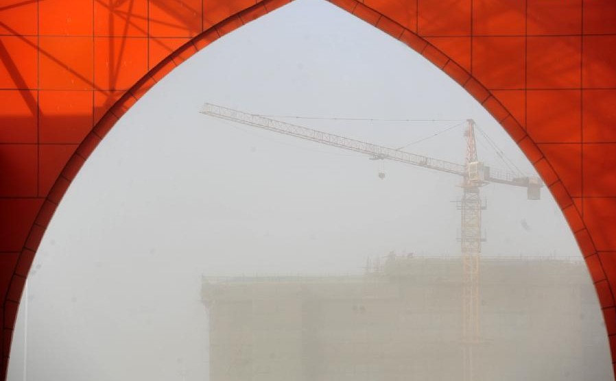 Photo taken on March 11, 2014 shows buildings shrouded in sand and dust storm in Zhongning county, Northwest China's Ningxia Hui autonomous region. Gale and sand storm hit Ningxia on Tuesday. [Photo/Xinhua] 