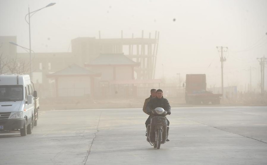 A villager rides bicycle amid sand and dust storm in Zhongning county, Northwest China's Ningxia Hui autonomous region, March 11, 2014. Gale and sand storm hit Ningxia on Tuesday. [Photo/Xinhua] 