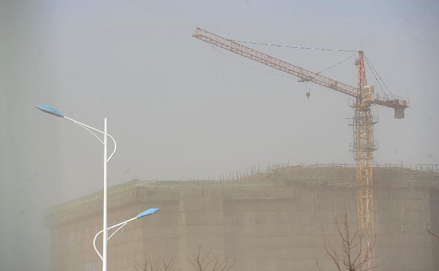 Photo taken on March 11, 2014 shows buildings shrouded in sand and dust storm in Zhongning county, Northwest China's Ningxia Hui autonomous region. Gale and sand storm hit Ningxia on Tuesday. [Photo/Xinhua] 