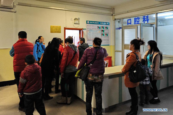 Parents take children to receive physical examination at a hospital in Jilin City, northeast China's Jilin Province, March 16, 2014.