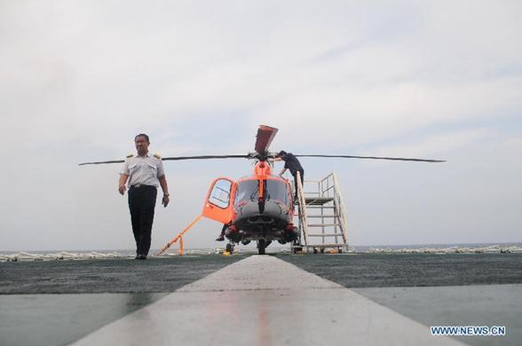 Photo taken on March 16, 2014 shows staff members making preparation for a helicopter on China's largest rescue vessel, Haixun 01. Haixun 01 headed toward Singapore on Tuesday to join in the search for missing Malaysia Airlines flight MH370. The vessel is estimated to arrive in the waters near Singapore for supplies on Wednesday before dawn and will continue its way to help search for the jet in waters near the Sunda Strait. 