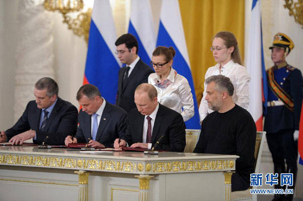 3月18日，俄罗斯总统普京在莫斯科克里姆林宫同克里米亚及塞瓦斯托波尔代表签署条约，允许克里米亚和塞瓦斯托波尔以联邦主体身份加入俄罗斯联邦。[新华社/俄新社]