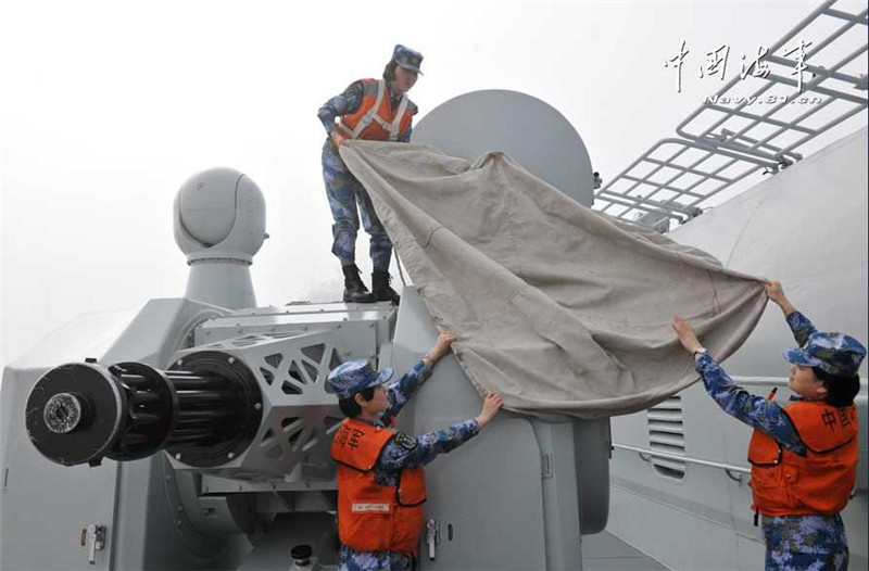 Trainee female sailors maintain a gun on board Liaoning. [Photo/navy.81.cn] 