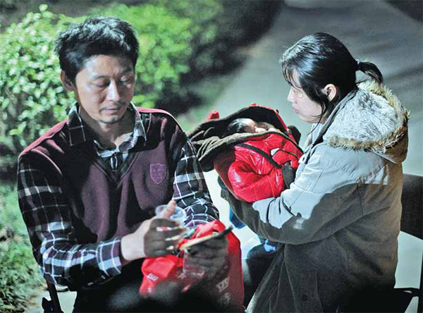 This couple from Guangzhou came to the hatch intending to give up their baby daughter, but later abandoned the idea. [Photo by Mo Weinong/For China Daily] 