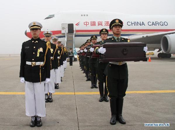 Soldiers of the Chinese People's Liberation Army carry coffins containing remains of soldiers of the Chinese People's Volunteers (CPV) dead in the 1950-53 Korean War, during a handover ceremony at the Incheon International Airport of South Korea, March 28, 2014.