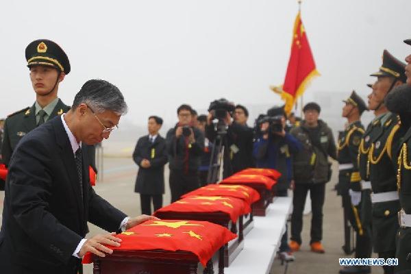 Chinese Ambassador to South Korea Qiu Guohong covers with a Chinese national flag a coffin containing remains of a soldier of the Chinese People's Volunteers (CPV) dead in the 1950-53 Korean War, during a handover ceremony at the Incheon International Airport in Incheon, South Korea, March 28, 2014. 