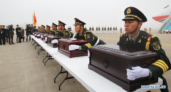 Soldiers of the Chinese People's Liberation Army carry coffins containing remains of soldiers of the Chinese People's Volunteers (CPV) dead in the 1950-53 Korean War, during a handover ceremony at the Incheon International Airport of South Korea, March 28, 2014. 