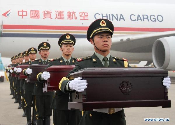 Soldiers of the Chinese People's Liberation Army carry coffins containing remains of soldiers of the Chinese People's Volunteers (CPV) dead in the 1950-53 Korean War, during a handover ceremony at the Incheon International Airport of South Korea, March 28, 2014.