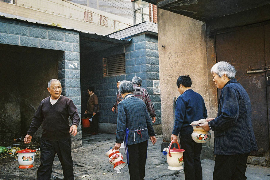 Local residents line up outside a public toilet to empty their chamber pots. The old houses in Mianbeili do not have toilets. [Photo/qq.com] 