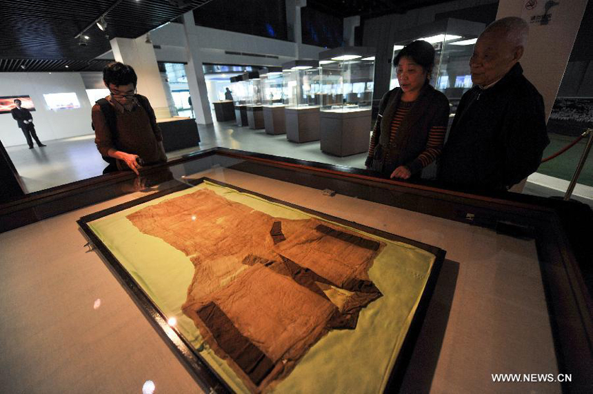 Visitors watch a displayed cultural relic at Hunan Provincial Museum in Changsha, capital of central China&apos;s Hunan Province, March 28, 2014. More than 50 pieces (sets) of cultural relics from the Mawangdui Tombs of the Han Dynasty (206 B.C. - 220 A.D.), located in the eastern suburbs of Changsha, will be officially re-presented at the museum from March 29.