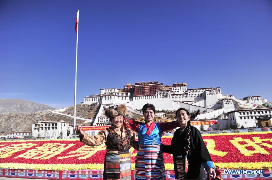 People pose for photos after a flag-raising ceremony celebrating the 55th anniversary of serfs&apos; emancipation in Lhasa, capital of southwest China&apos;s Tibet Autonomous Region, March 28, 2014.