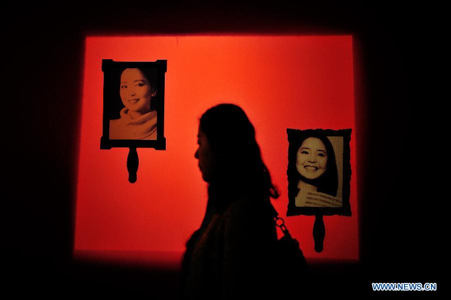 A visitor walks past pictures of singer Teresa Teng during a special exhibition themed in Teng, at the Hubei provincial museum in Wuhan, capital of central China&apos;s Hubei Province, March 28, 2014.